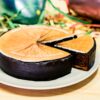 Schokoladenkuchen mit orange-gelbem Fondant-Schmetterlingsmotiv auf weißem Teller, ein Stück abgeschnitten