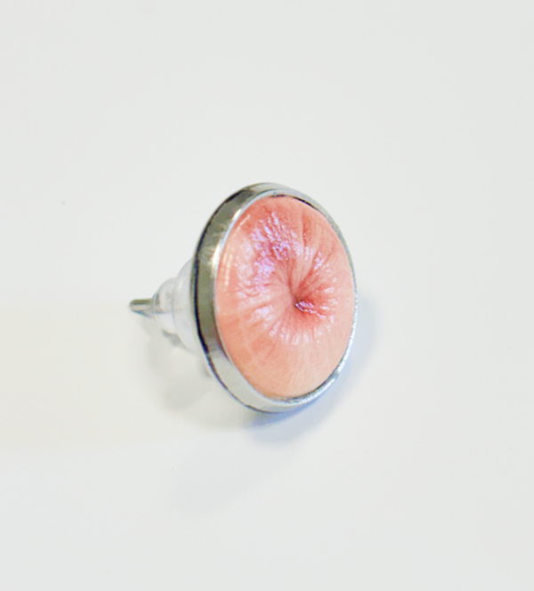 Lutscher mit stilisiertem Nippel-Motiv in Rosa auf metallischer Halterung