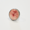 Ring mit stilisiertem Anus-Motiv in rosafarbener Ausführung in Metallring-Fassung